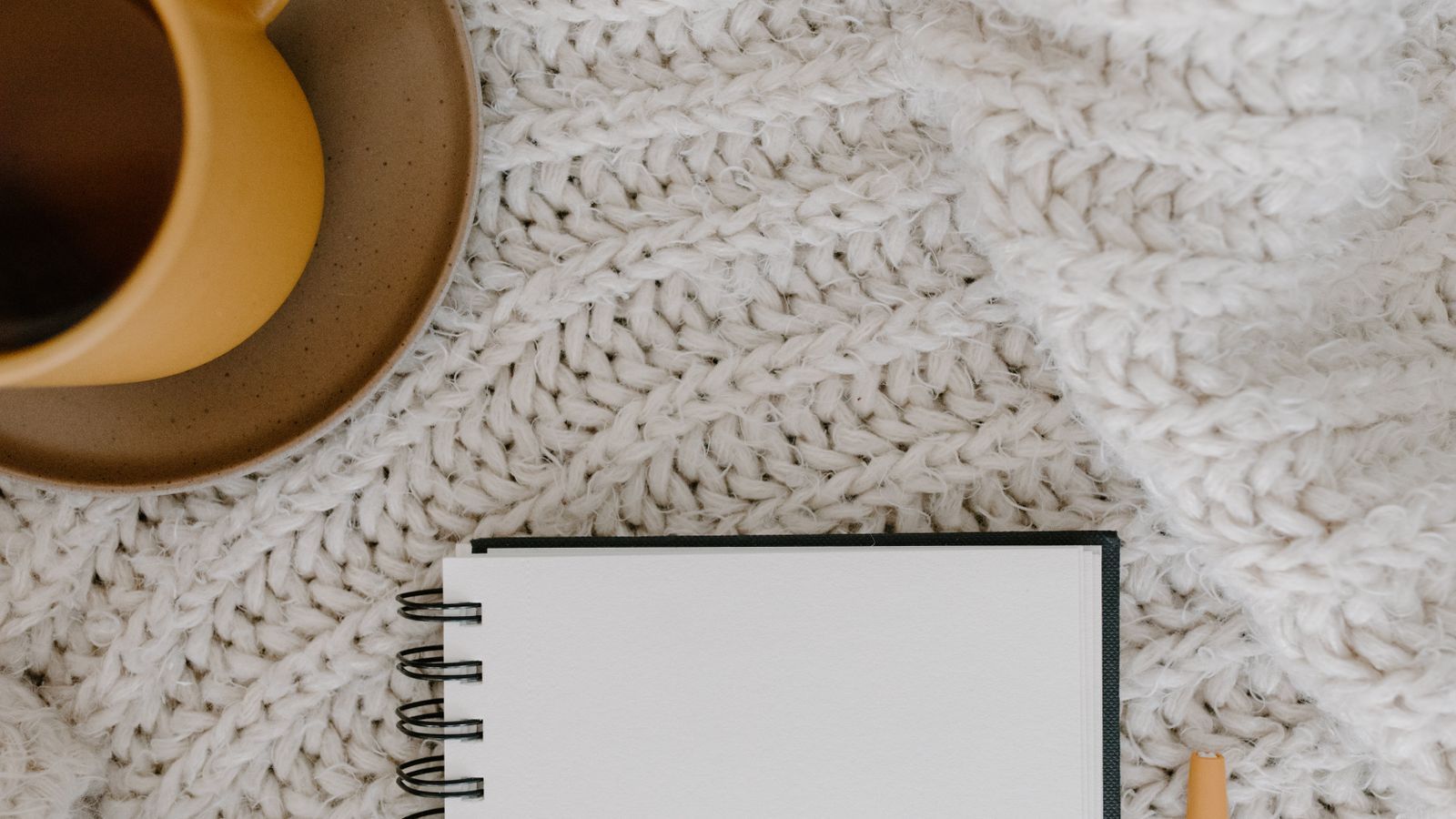 Cozy sofa with a knitted blanket and mug on a side table