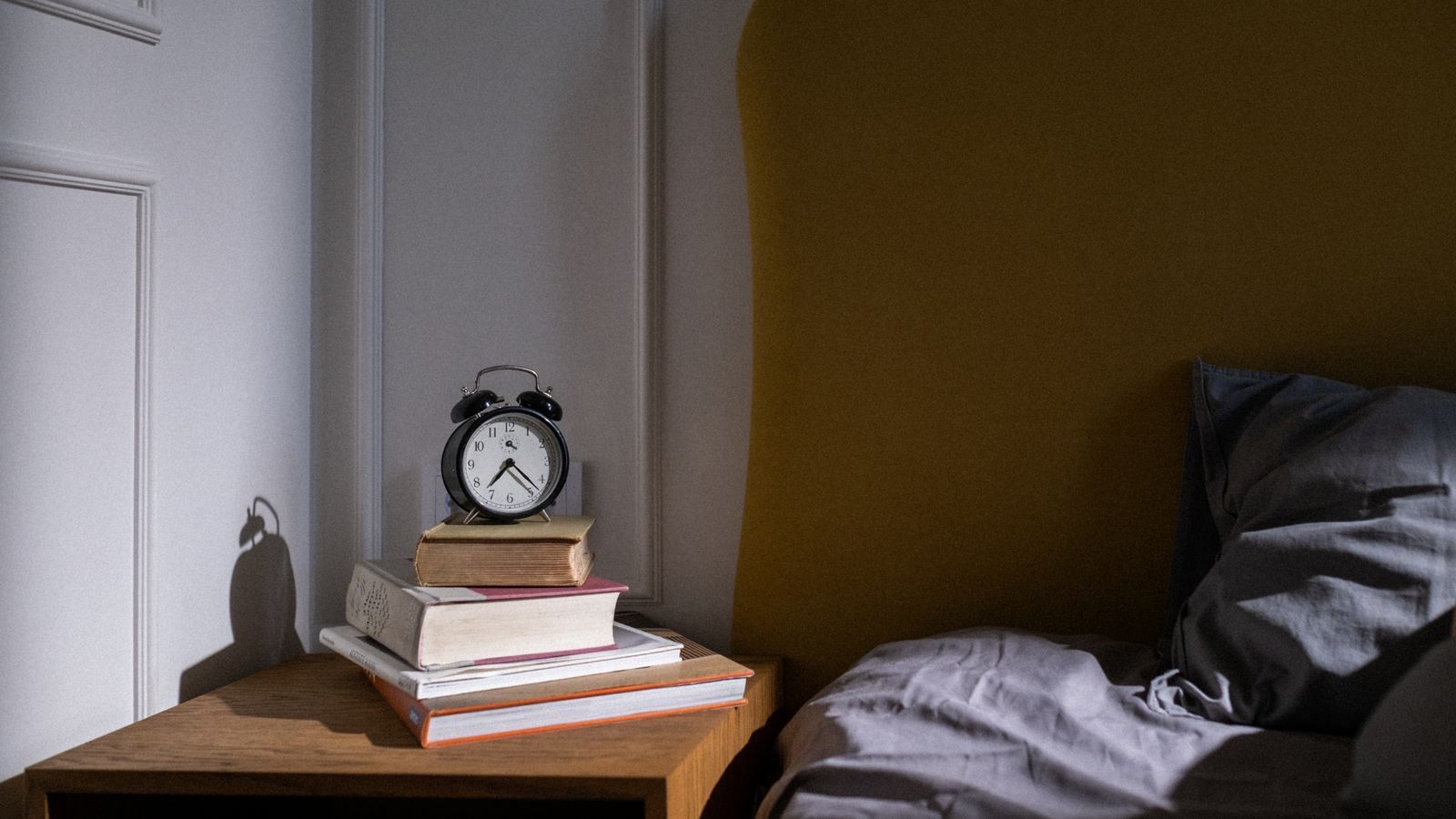 alarm clock on bedside table with soft morning light