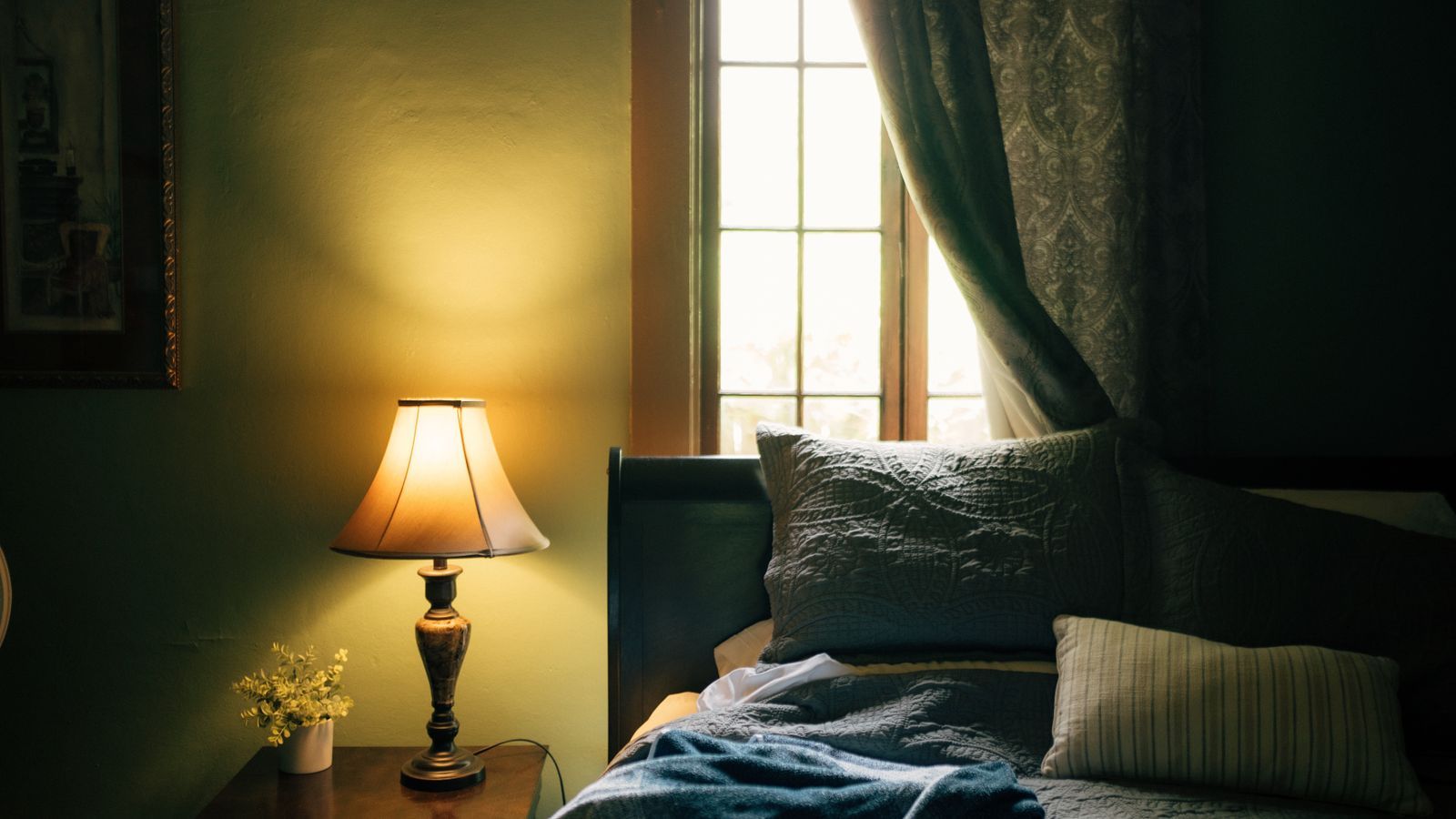Two pillows on a bed with warm bedside lamp glow